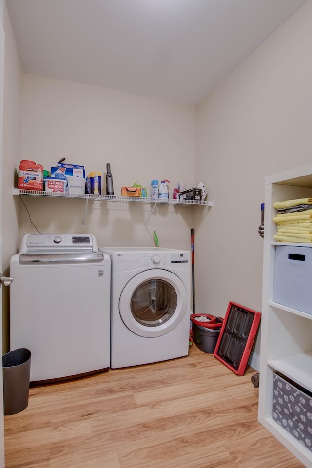 laundry room with laundry area, washer and clothes dryer, and wood finished floors