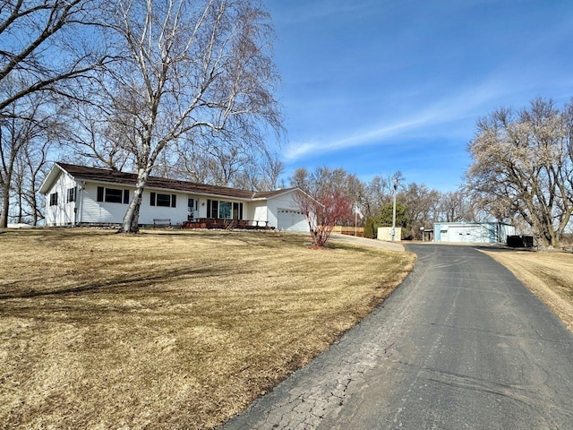 ranch-style house featuring a garage, a front yard, and driveway