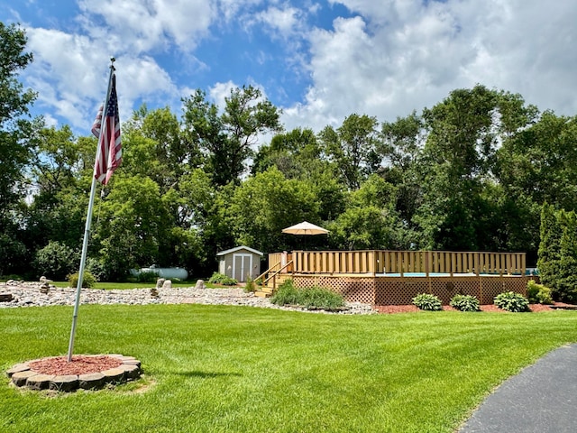 1001 1st Ave NW, Pelican Rapids, MN 56572 - view of grassy yard featuring a storage unit, a deck, and view of wooded area