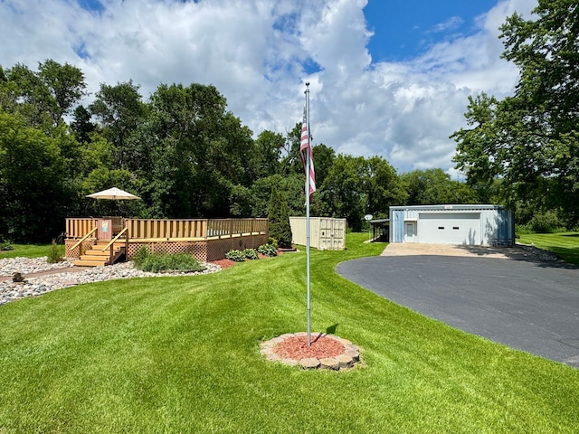 1001 1st Ave NW, Pelican Rapids, MN 56572 - view of green lawn featuring a detached garage, a wooden deck, an outdoor structure, and view of wooded area