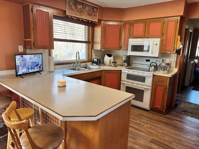 1001 1st Ave NW, Pelican Rapids, MN 56572 - kitchen with white appliances, a peninsula, light countertops, and dark wood finished floors
