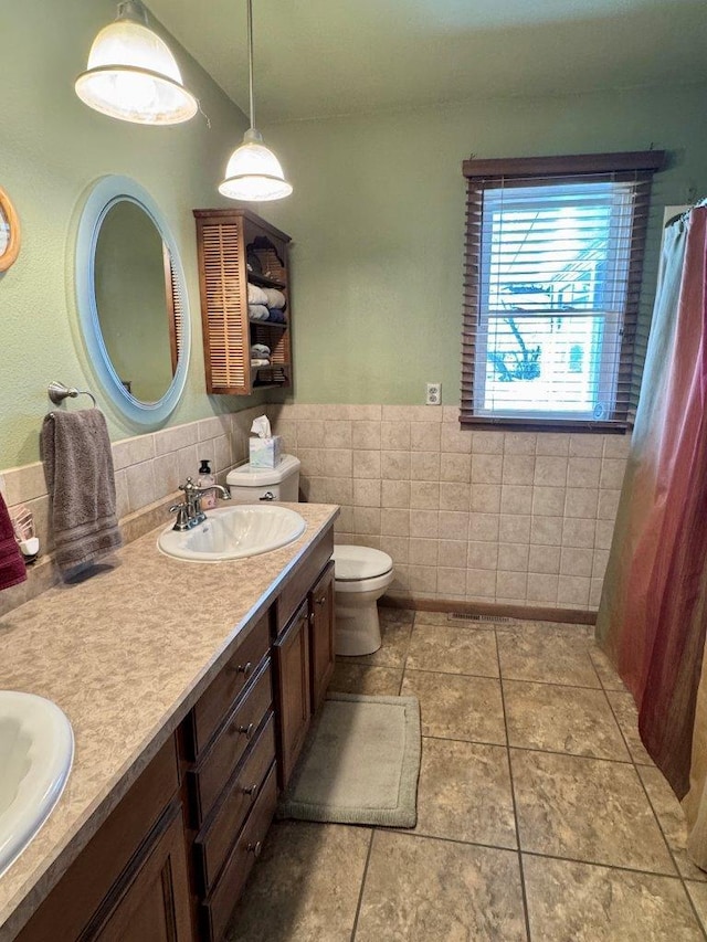 1001 1st Ave NW, Pelican Rapids, MN 56572 - bathroom featuring double vanity, tile walls, wainscoting, and tile patterned floors
