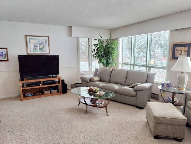 carpeted living area with a baseboard heating unit, a textured ceiling, and a wainscoted wall