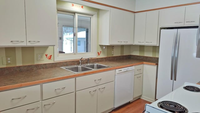 kitchen featuring white appliances, dark countertops, light wood-type flooring, white cabinetry, and a sink