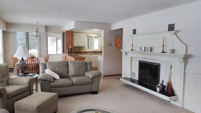 living room with light carpet, a fireplace, visible vents, and a textured ceiling