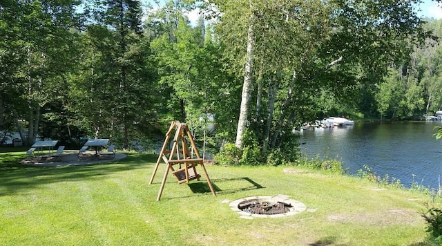 view of yard with a water view and an outdoor fire pit