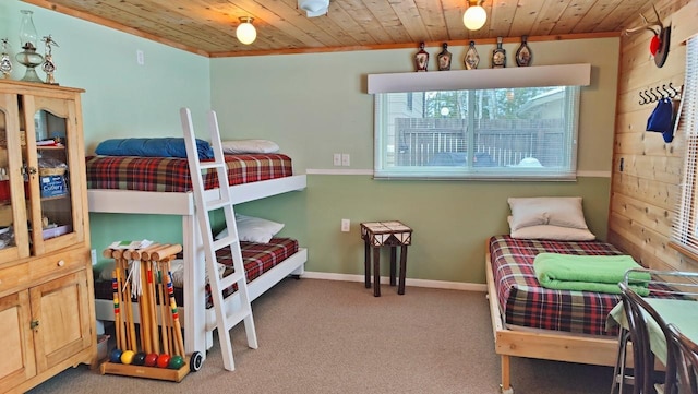 bedroom with carpet floors, wooden ceiling, and baseboards