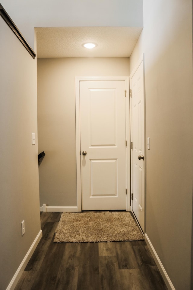 hall featuring wood finished floors and baseboards