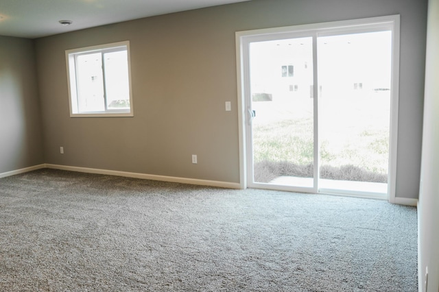 empty room featuring baseboards and carpet