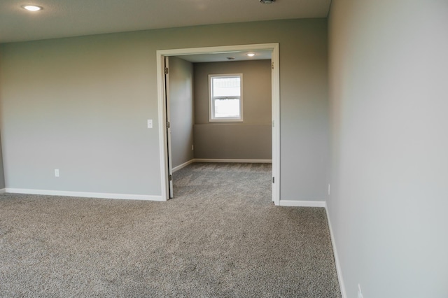 empty room featuring carpet flooring, recessed lighting, and baseboards