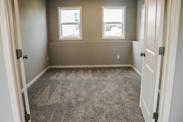 unfurnished room featuring baseboards and carpet