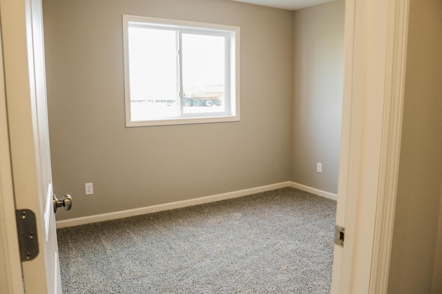 carpeted spare room with baseboards