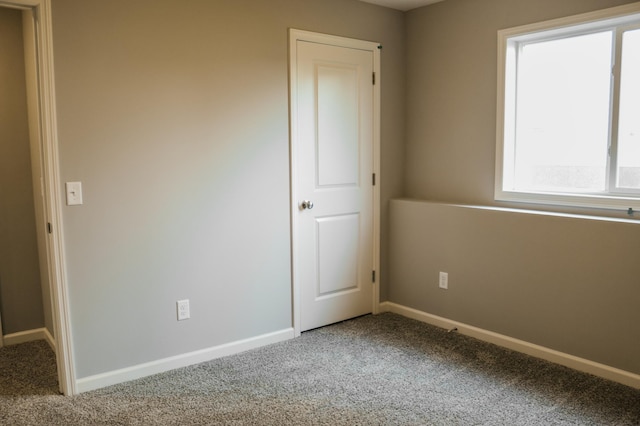 unfurnished bedroom featuring carpet flooring and baseboards