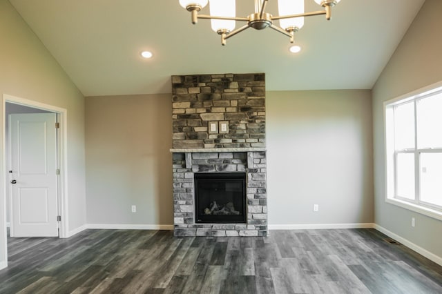 unfurnished living room with a stone fireplace, dark wood-type flooring, and vaulted ceiling