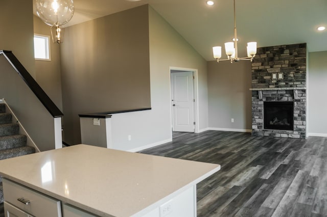 kitchen featuring a fireplace, a chandelier, dark wood-style flooring, and light countertops