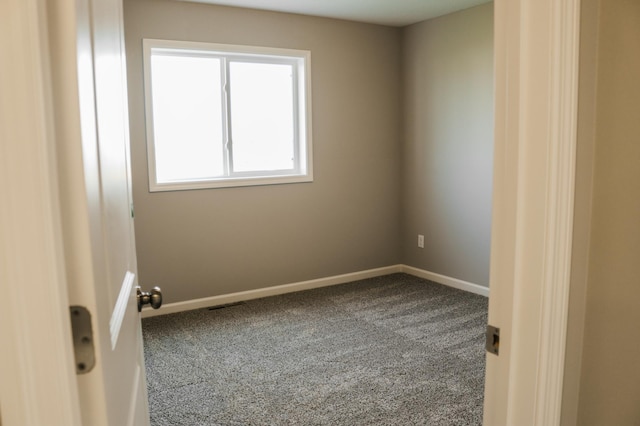 unfurnished room with visible vents, baseboards, and carpet