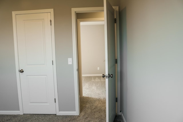 hall with carpet flooring and baseboards