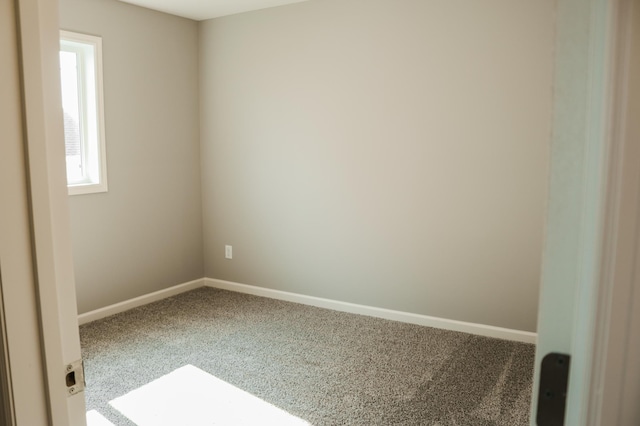 carpeted spare room featuring baseboards