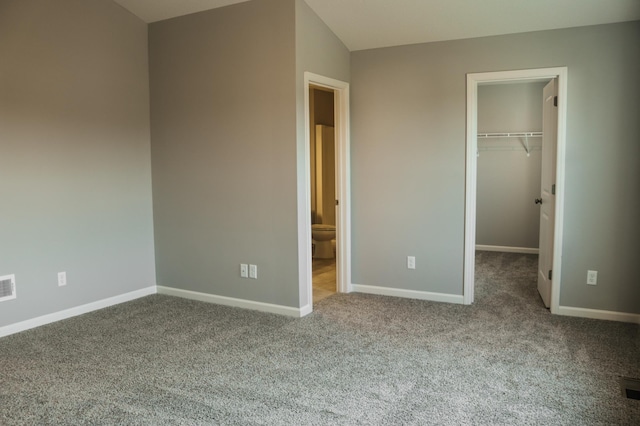 unfurnished bedroom with visible vents, a closet, carpet floors, baseboards, and a spacious closet