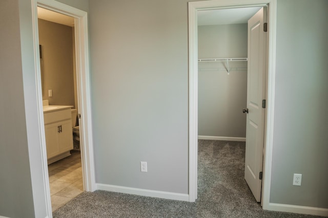 unfurnished bedroom with light carpet, baseboards, and a closet