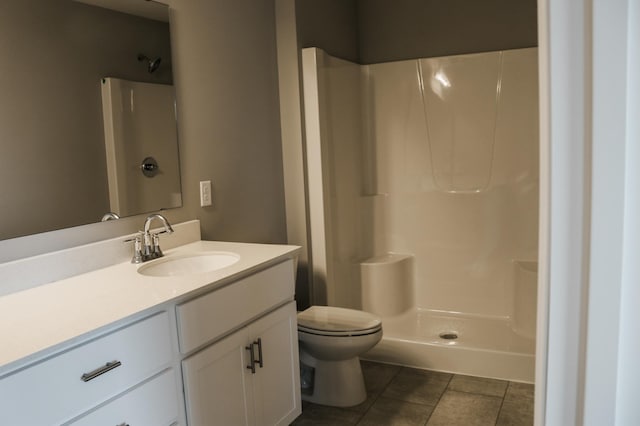 bathroom with a shower, toilet, vanity, and tile patterned flooring