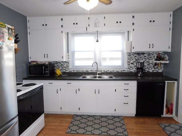 kitchen featuring dark countertops, wood finished floors, stainless steel appliances, and a sink