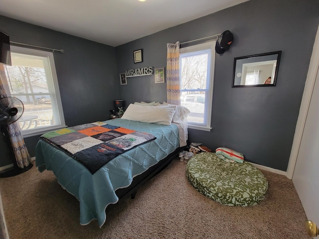 carpeted bedroom with multiple windows and baseboards