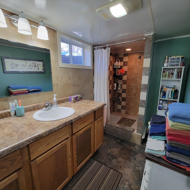 bathroom with ornamental molding, vanity, and a tile shower