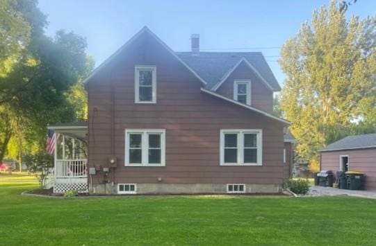 rear view of house with a lawn and covered porch