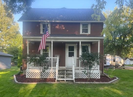 back of property featuring a lawn and a porch