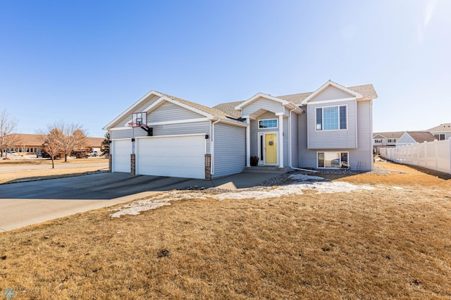 view of front of property with an attached garage, concrete driveway, and fence