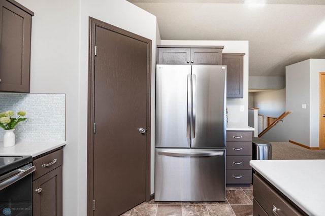 kitchen with decorative backsplash, dark brown cabinets, stainless steel appliances, and light countertops