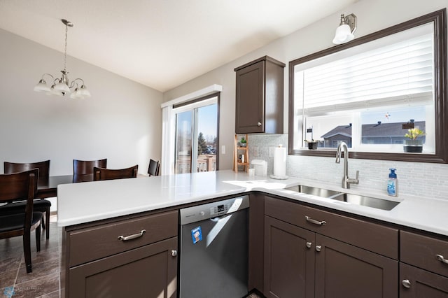 kitchen with stainless steel dishwasher, a peninsula, dark brown cabinetry, and a sink