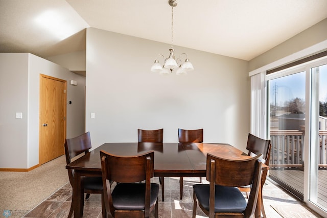 carpeted dining space featuring lofted ceiling, baseboards, and a chandelier