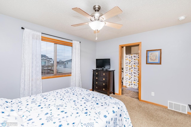 carpeted bedroom featuring visible vents, baseboards, a textured ceiling, and a ceiling fan