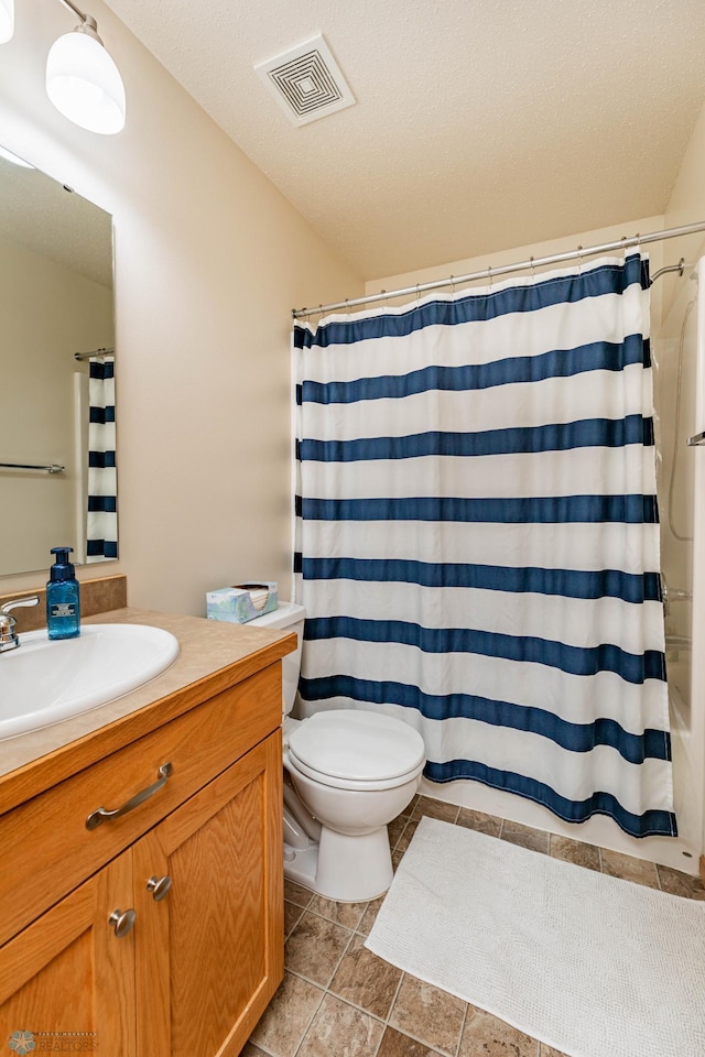 bathroom featuring visible vents, toilet, vanity, tile patterned floors, and a textured ceiling