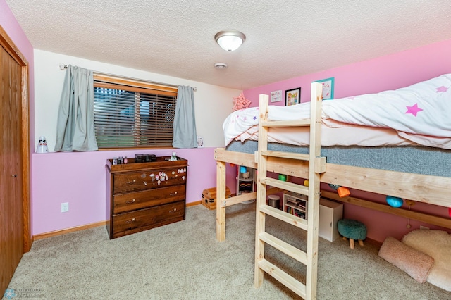 carpeted bedroom featuring baseboards, a closet, and a textured ceiling