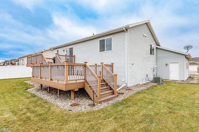 rear view of house featuring a lawn, a deck, and fence