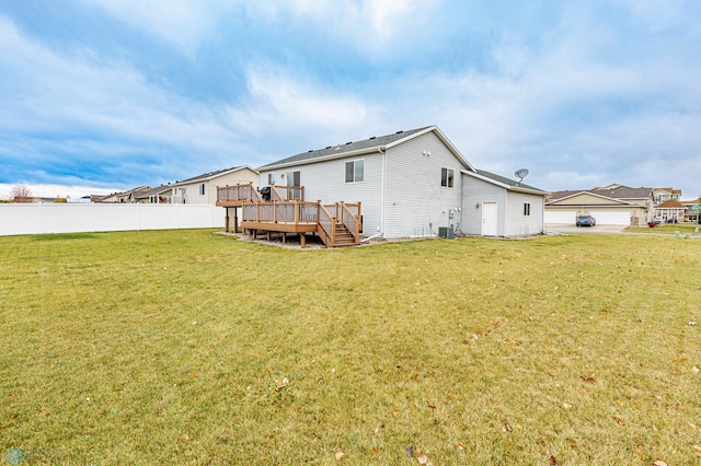 rear view of property with a deck, central AC, a yard, and fence