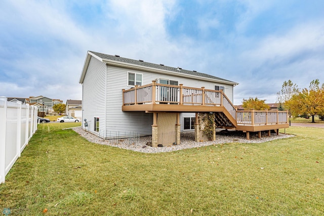 rear view of house with a deck, a yard, and fence