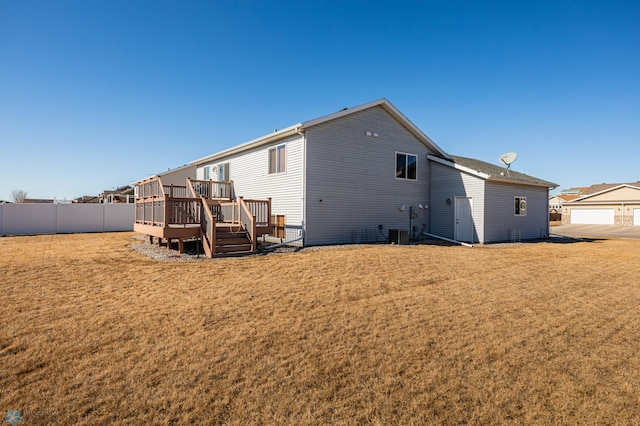 back of house with central AC unit, a lawn, a deck, and fence