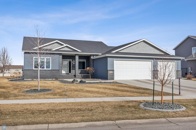 view of front facade featuring brick siding, an attached garage, driveway, and a front yard