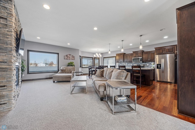 living room with a notable chandelier, recessed lighting, baseboards, and wood finished floors