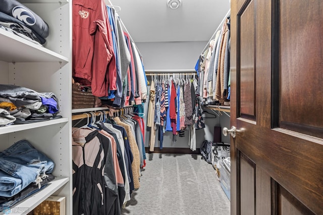 walk in closet featuring light carpet