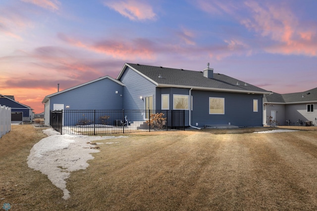 back of property at dusk featuring a patio area, a chimney, and fence