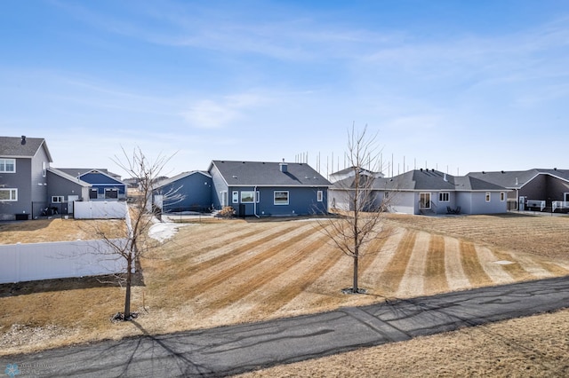 ranch-style home featuring a residential view and fence