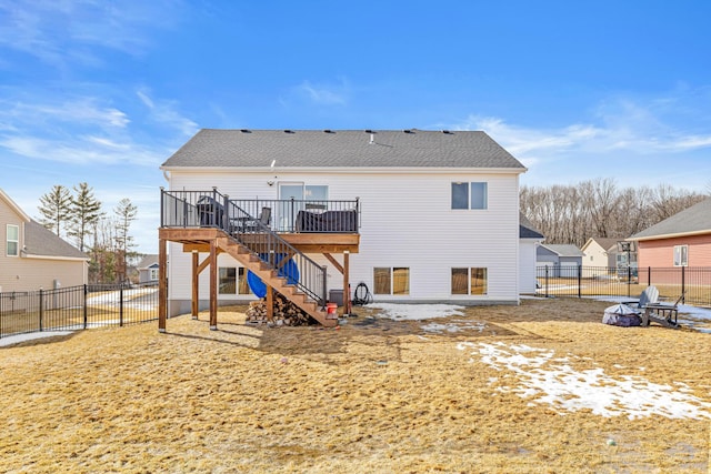 rear view of property with a deck, stairway, a fenced backyard, and a shingled roof