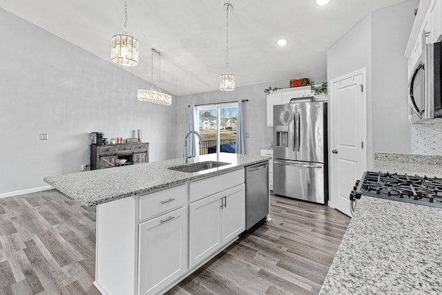 kitchen featuring a sink, appliances with stainless steel finishes, a notable chandelier, and light wood finished floors
