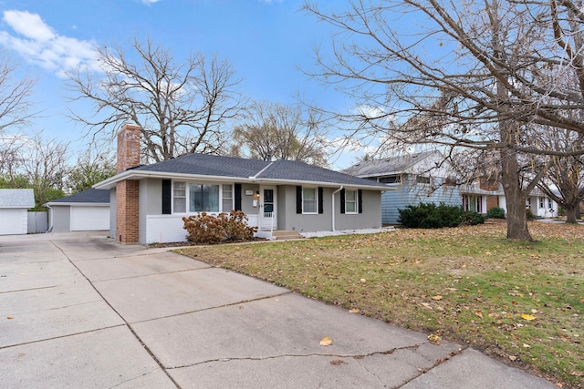 ranch-style home featuring an outdoor structure, a front lawn, brick siding, and a chimney