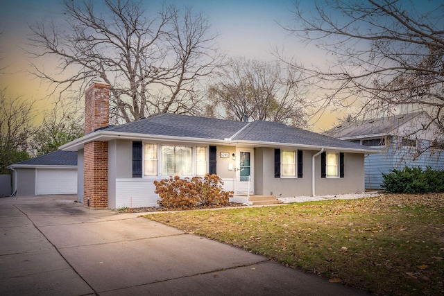 ranch-style house with an outbuilding, a front yard, a chimney, concrete driveway, and a garage